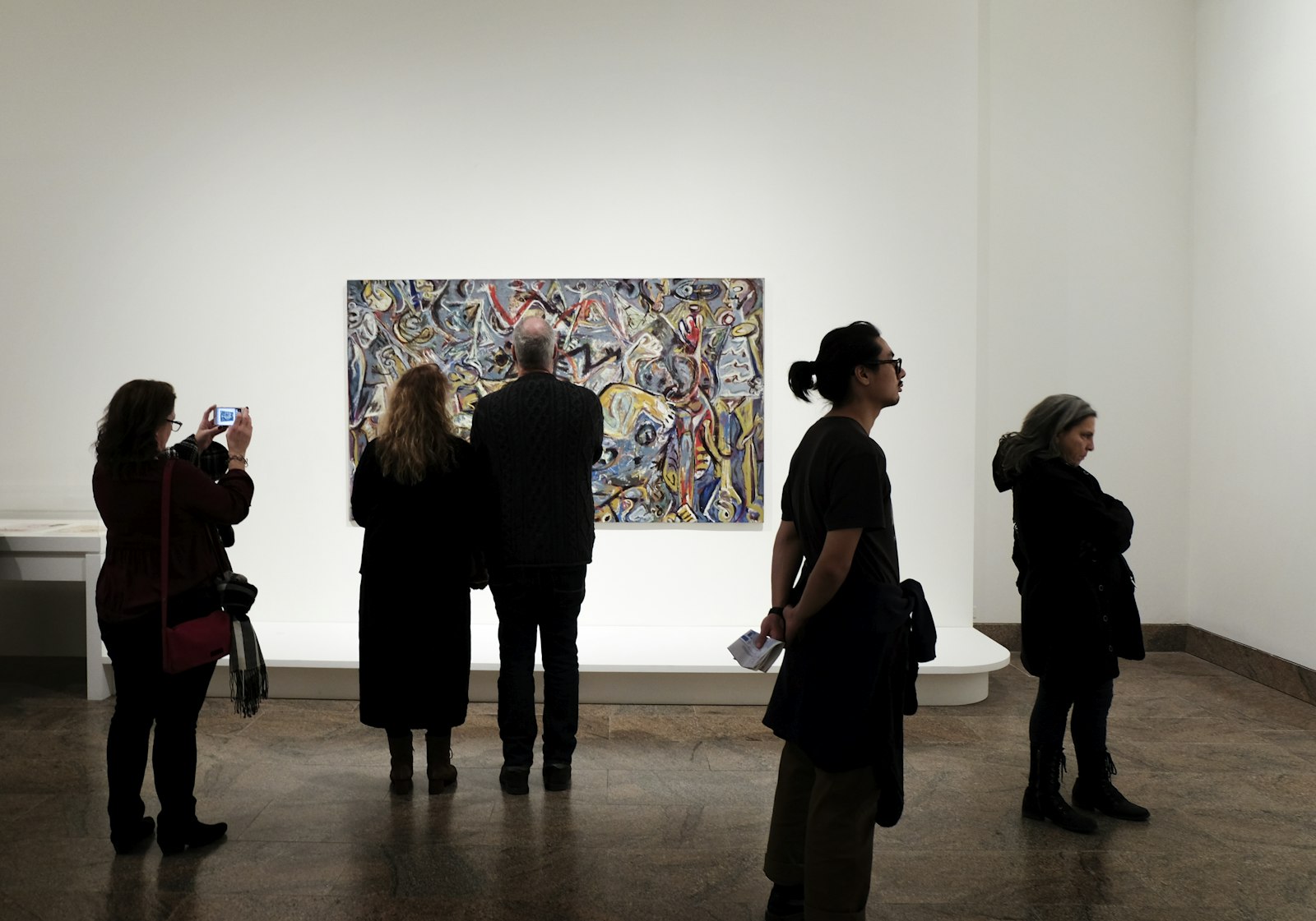 Un gruppo di visitatori davanti a un quadro in una sala espositiva