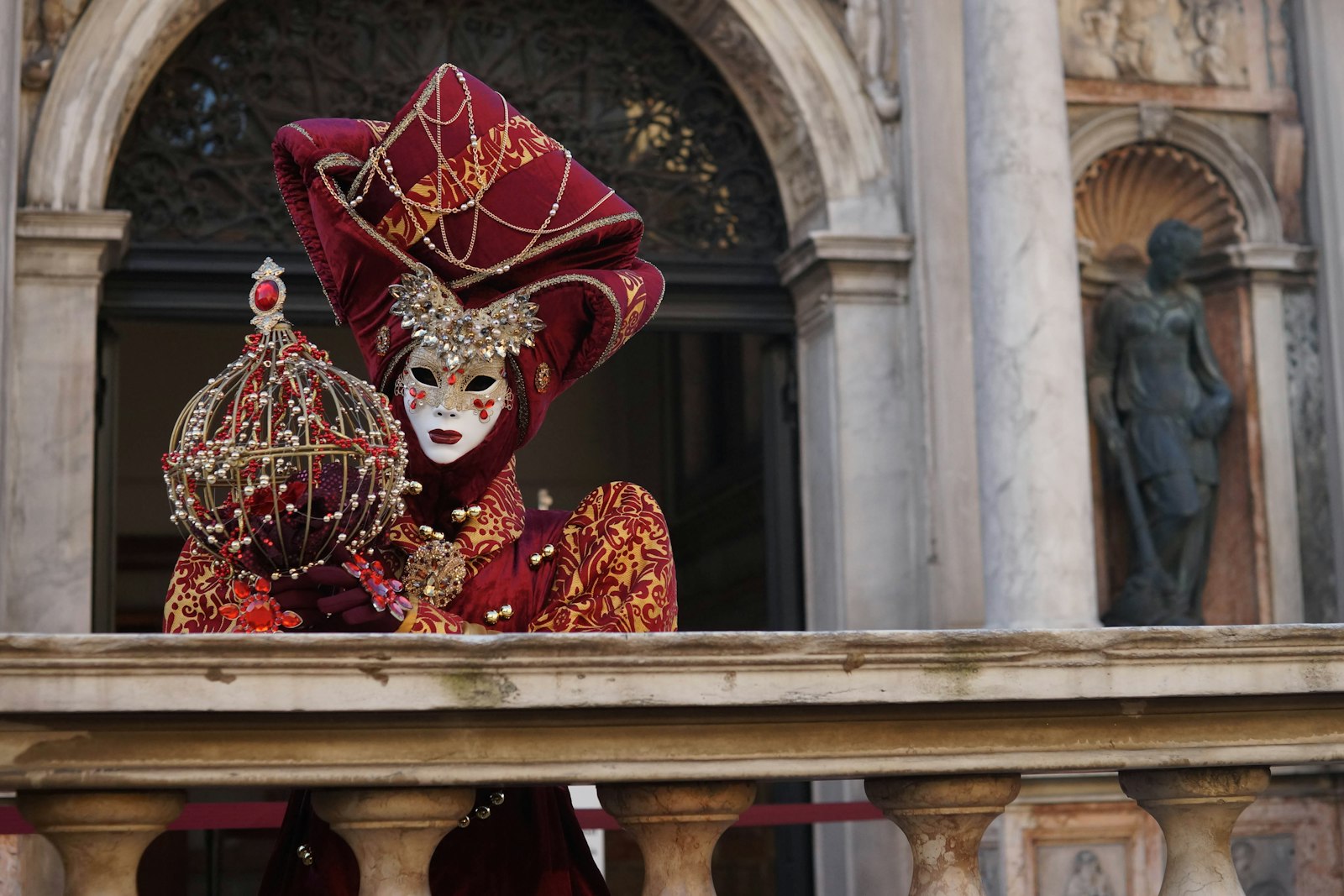 Una maschera veneziana in costume su un balcone
